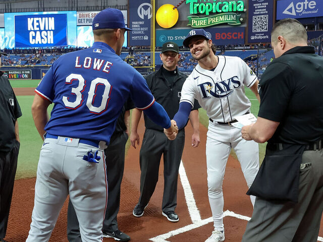 ST. PETERSBURG, FL - JUNE 10: Nathaniel Lowe (L) #30 of the Texas Rangers and his brother Josh Lowe (R) #15 of the Tampa Bay Rays exchange lineup cards prior to a baseball game at Tropicana Field on June 10, 2023 in St. Petersburg, Florida.