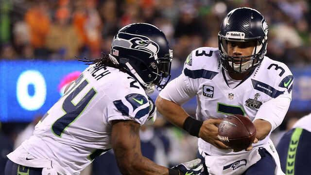 EAST RUTHERFORD, NJ - FEBRUARY 02: Quarterback Russell Wilson #3 looks ot hand off to running back Marshawn Lynch #24 of the Seattle Seahawks during Super Bowl XLVIII against the Denver Broncos at MetLife Stadium on February 2, 2014 in East Rutherford, New Jersey.