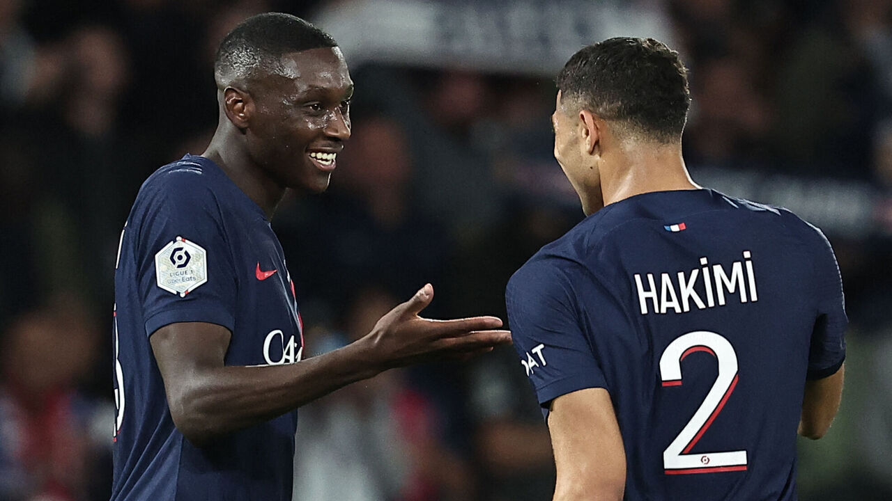 Paris Saint-Germain's French forward #23 Randal Kolo Muani (L) celebrates with Paris Saint-Germain's Moroccan defender #02 Achraf Hakimi (R) after scoring a goal during the French L1 football match between Paris Saint-Germain (PSG) and Olympique de Marseille (OM) at The Parc des Princes Stadium in Paris on September 24, 2023.