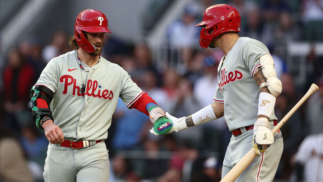 ATLANTA, GEORGIA - OCTOBER 07: Bryce Harper #3 and Nick Castellanos #8 of the Philadelphia Phillies react following a run scored by Harper during the fourth inning against the Atlanta Braves during Game One of the Division Series at Truist Park on October 07, 2023 in Atlanta, Georgia.