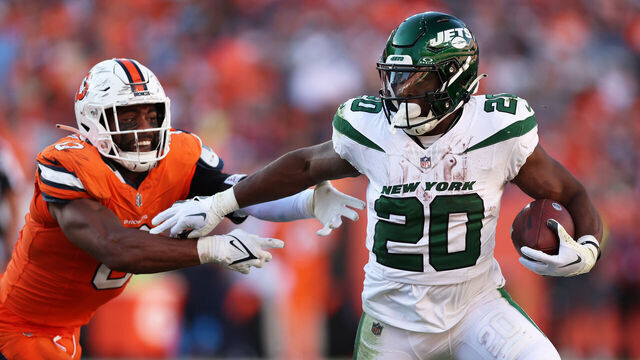 DENVER, COLORADO - OCTOBER 08: Breece Hall #20 of the New York Jets runs with the ball while being chased by Jonathon Cooper #0 of the Denver Broncos in the fourth quarter at Empower Field At Mile High on October 08, 2023 in Denver, Colorado.