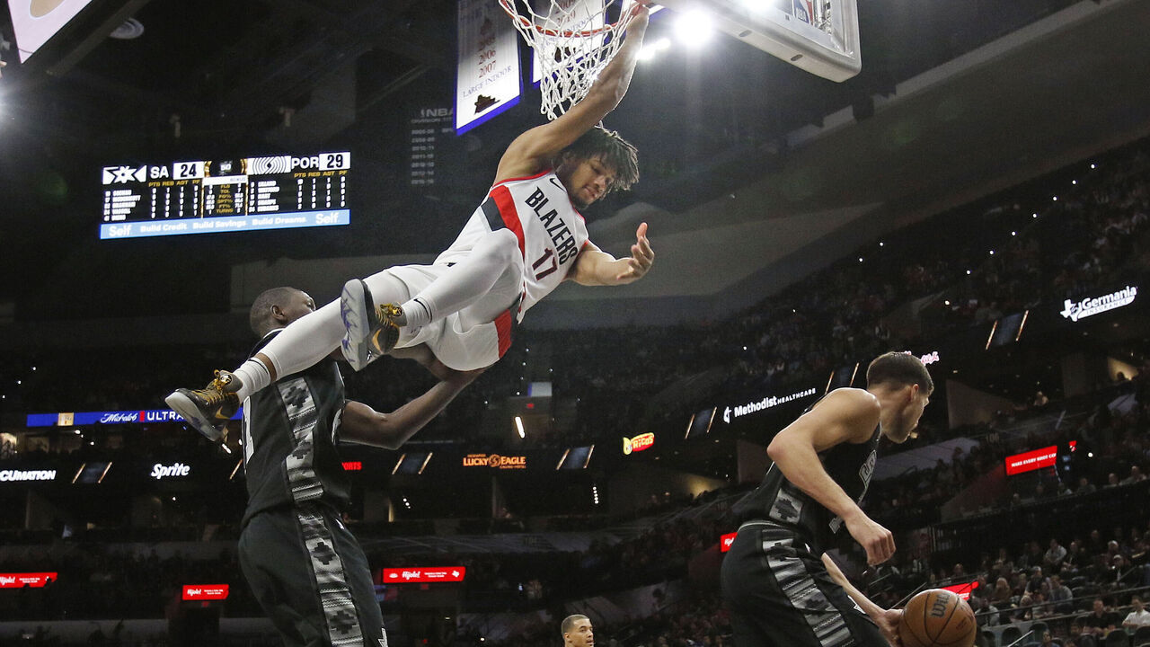 SAN ANTONIO, TX - DECEMBER 14: Shaedon Sharpe #17 of the Portland Trail Blazers hangs onto the basket after dunking against the San Antonio Spurs in the first half at AT&T Center on December 14, 2022 in San Antonio, Texas. NOTE TO USER: User expressly acknowledges and agrees that, by downloading and or using this photograph, User is consenting to terms and conditions of the Getty Images License Agreement.