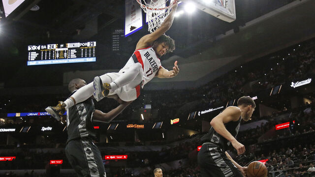 SAN ANTONIO, TX - DECEMBER 14: Shaedon Sharpe #17 of the Portland Trail Blazers hangs onto the basket after dunking against the San Antonio Spurs in the first half at AT&T Center on December 14, 2022 in San Antonio, Texas. NOTE TO USER: User expressly acknowledges and agrees that, by downloading and or using this photograph, User is consenting to terms and conditions of the Getty Images License Agreement.
