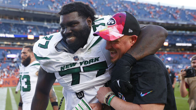 DENVER, COLORADO - OCTOBER 08: Mekhi Becton #77 and offensive coordinator Nathaniel Hackett of the New York Jets celebrate after beating the Denver Broncos 31-21 at Empower Field At Mile High on October 08, 2023 in Denver, Colorado.