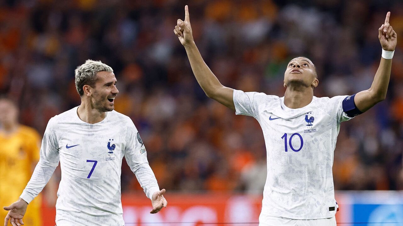 France's forward Kylian Mbappé (R) celebrates with France's forward Antoine Griezmann (L) after scoring his team's second goal during the Euro 2024 qualifying football match between the Netherlands and France at the Johan Cruijff ArenA in Amsterdam on October 13, 2023.