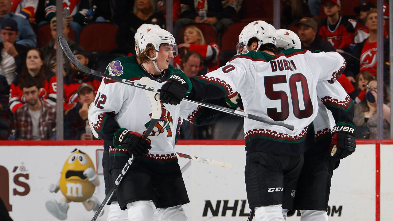 NEWARK, NEW JERSEY - OCTOBER 13: Logan Cooley #92 and Sean Durzi #50 of the Arizona Coyotes celebrate Durzi's second period goal against the New Jersey Devils at Prudential Center on October 13, 2023 in Newark, New Jersey.