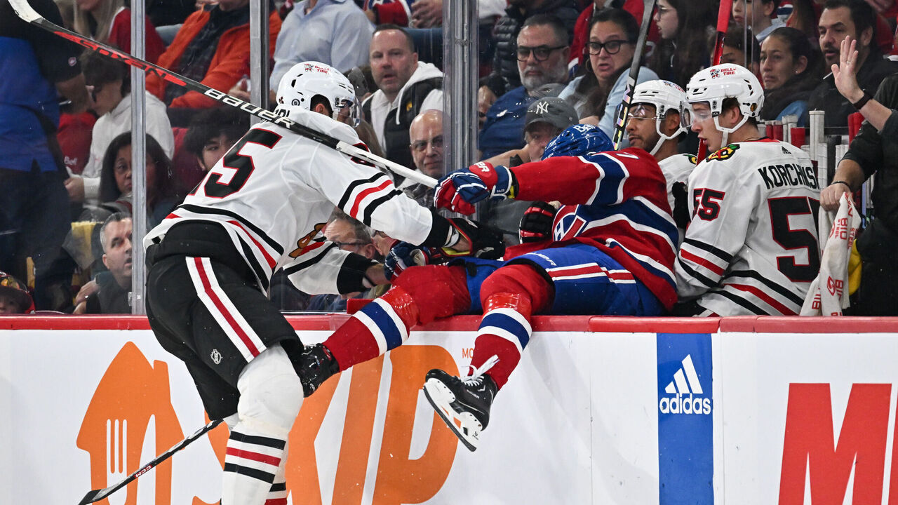 MONTREAL, CANADA - OCTOBER 14: Jarred Tinordi #25 of the Chicago Blackhawks pushes Kirby Dach #77 of the Montreal Canadiens into the Blackhawks bench during the first period at the Bell Centre on October 14, 2023 in Montreal, Quebec, Canada.