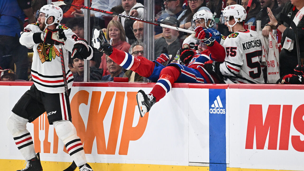 MONTREAL, CANADA - OCTOBER 14: Jarred Tinordi #25 of the Chicago Blackhawks pushes Kirby Dach #77 of the Montreal Canadiens into the Blackhawks bench during the first period at the Bell Centre on October 14, 2023 in Montreal, Quebec, Canada.