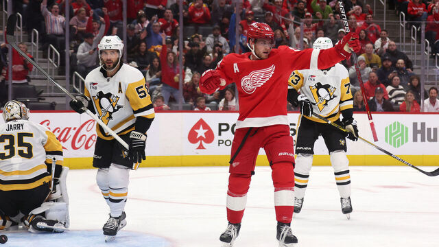 DETROIT, MICHIGAN - OCTOBER 18: Andrew Copp #18 of the Detroit Red Wings celebrates his second period goal next to Kris Letang #58 of the Pittsburgh Penguins at Little Caesars Arena on October 18, 2023 in Detroit, Michigan.