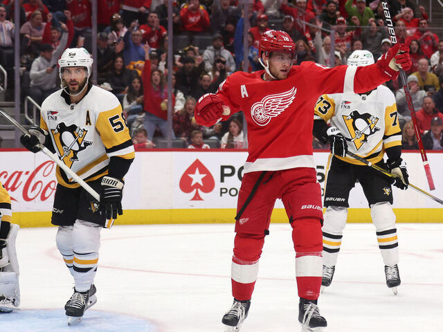 DETROIT, MICHIGAN - OCTOBER 18: Andrew Copp #18 of the Detroit Red Wings celebrates his second period goal next to Kris Letang #58 of the Pittsburgh Penguins at Little Caesars Arena on October 18, 2023 in Detroit, Michigan.