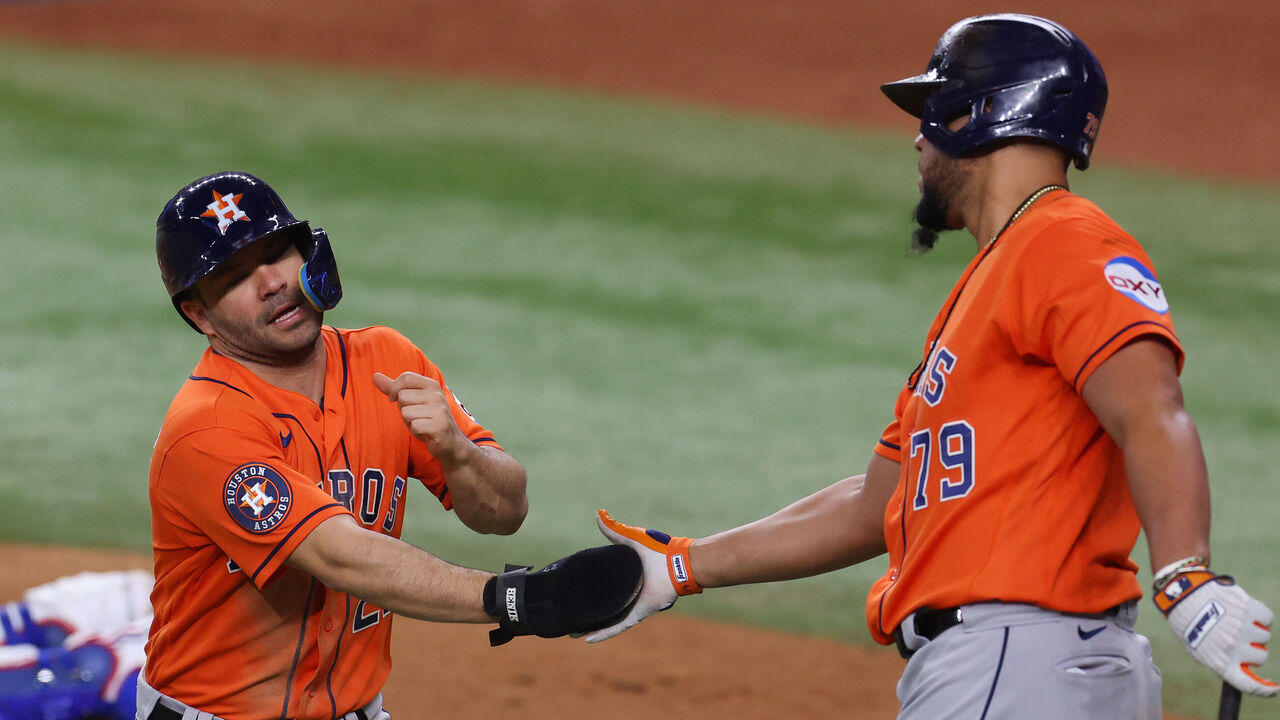 ARLINGTON, TEXAS - OCTOBER 19: Jose Altuve #27 and José Abreu #79 of the Houston Astros celebrate after Altuve scored a run in the eighth inning against the Texas Rangers during Game Four of the Championship Series at Globe Life Field on October 19, 2023 in Arlington, Texas.