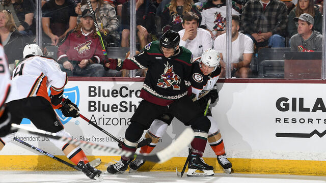 TEMPE, ARIZONA - OCTOBER 21: Travis Dermott #33 of the Arizona Coyotes battles for a loose puck with Ryan Strome #16 and Cam Fowler #4 of the Anaheim Ducks during the first period at Mullett Arena on October 21, 2023 in Tempe, Arizona.