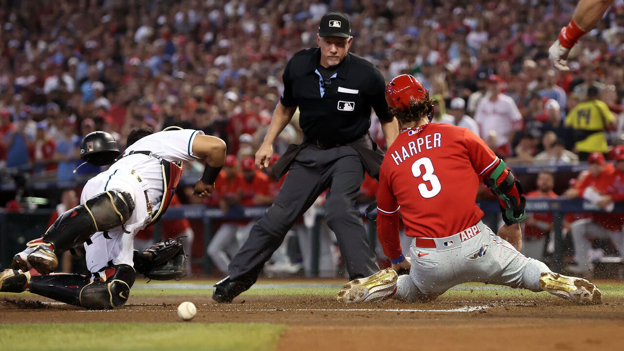PHOENIX, ARIZONA - OCTOBER 21: Bryce Harper #3 of the Philadelphia Phillies collides with Gabriel Moreno #14 of the Arizona Diamondbacks to score a run during the first inning in Game Five of the National League Championship Series at Chase Field on October 21, 2023 in Phoenix, Arizona.