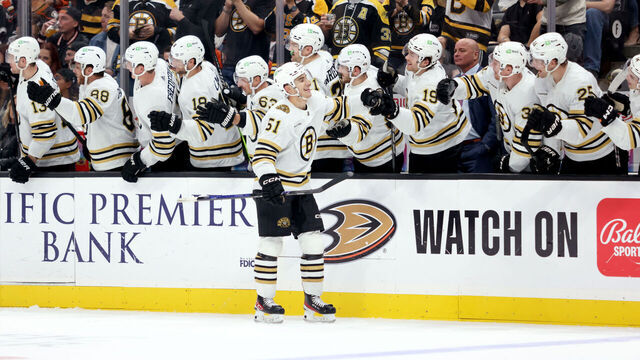 ANAHEIM, CALIFORNIA - OCTOBER 22: Matthew Poitras #51 of the Boston Bruins high fives teammates at the bench after scoring a goal in the third period of the game against the Anaheim Ducks at Honda Center on October 22, 2023 in Anaheim, California.
