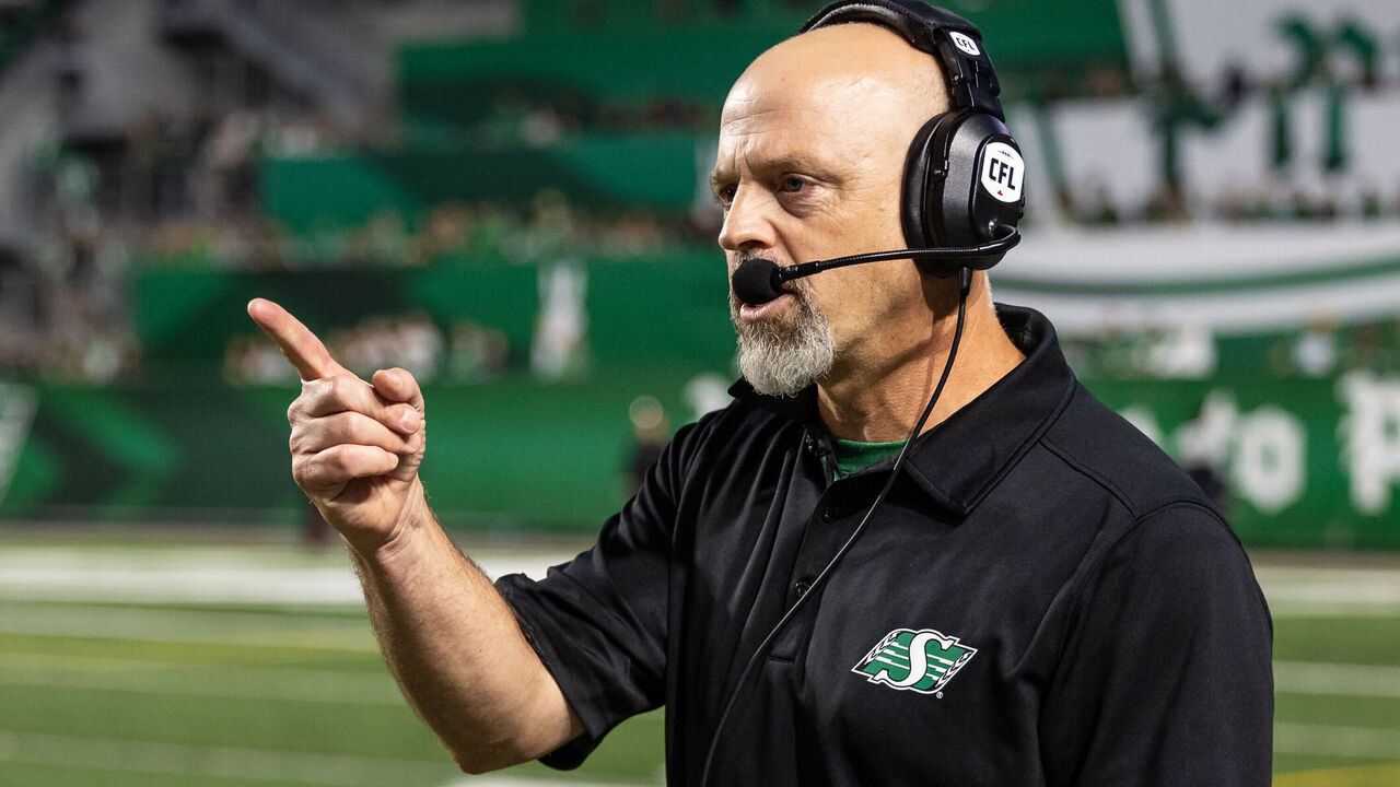 REGINA, CANADA - AUGUST 20: Head coach Craig Dickenson of the Saskatchewan Roughriders makes a call on the sideline in the game between the BC Lions and Saskatchewan Roughriders at Mosaic Stadium on August 20, 2023 in Regina, Canada.