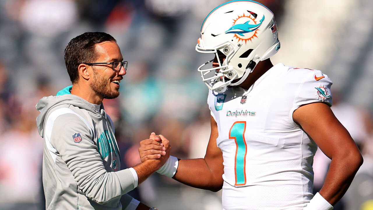 CHICAGO, ILLINOIS - NOVEMBER 06: Head coach Mike McDaniel of the Miami Dolphins speaks with Tua Tagovailoa #1 prior to the game against the Chicago Bears at Soldier Field on November 06, 2022 in Chicago, Illinois.