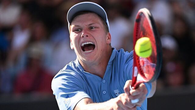 TOPSHOT - USA's Jenson Brooksby hits a return against USA's Tommy Paul during their men's singles match on day six of the Australian Open tennis tournament in Melbourne on January 21, 2023. - -- IMAGE RESTRICTED TO EDITORIAL USE - STRICTLY NO COMMERCIAL USE --