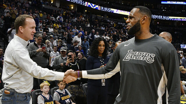 DENVER, CO - DECEMBER 03: Former Denver Broncos QB Peyton Manning, left, greets LeBron James (23) of the Los Angeles Lakers before the game against the Denver Nuggets at the Pepsi Center December 03, 2019.