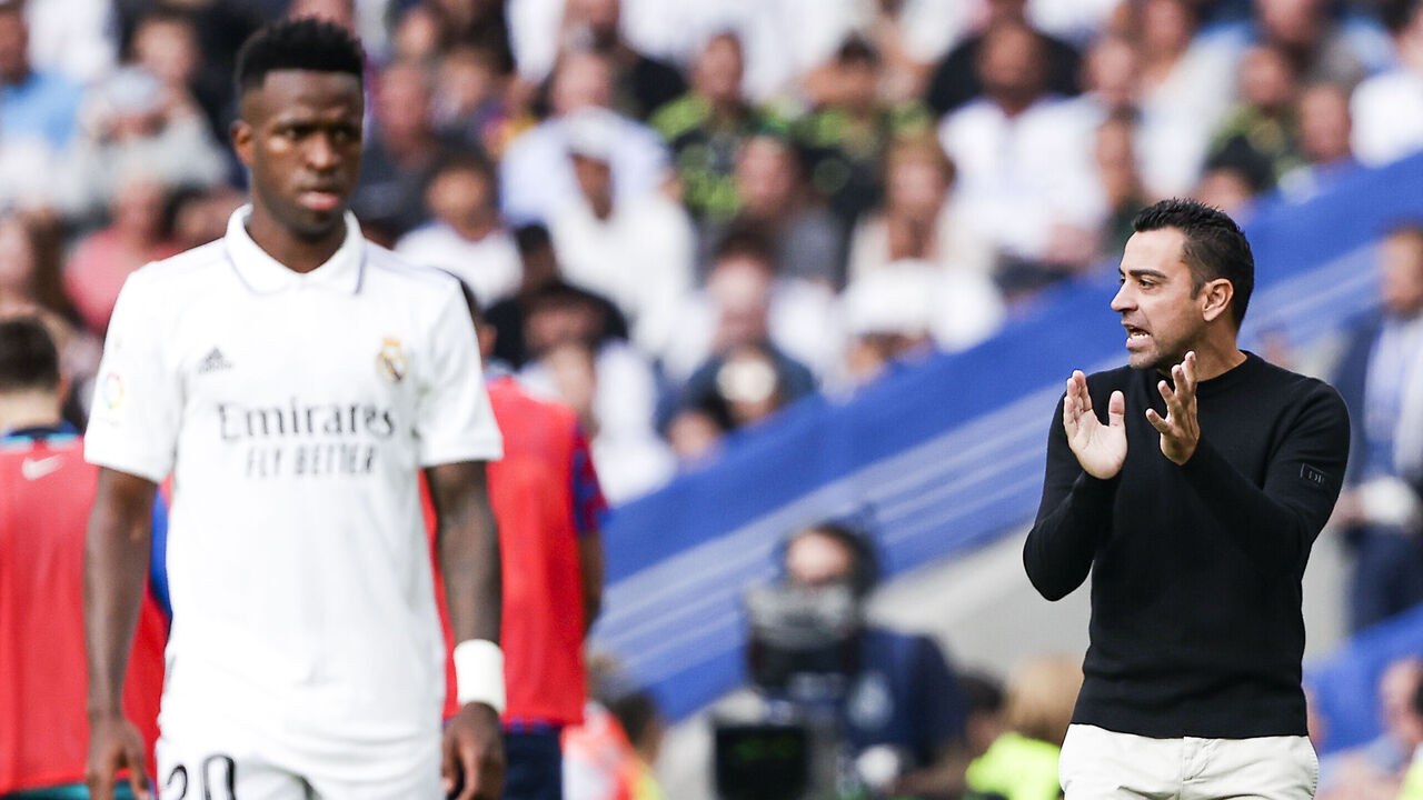 MADRID, SPAIN - OCTOBER 16: (L-R) Vinicius Junior of Real Madrid, coach Xavi Hernandez of FC Barcelona during the La Liga Santander match between Real Madrid v FC Barcelona at the Estadio Santiago Bernabeu on October 16, 2022 in Madrid Spain