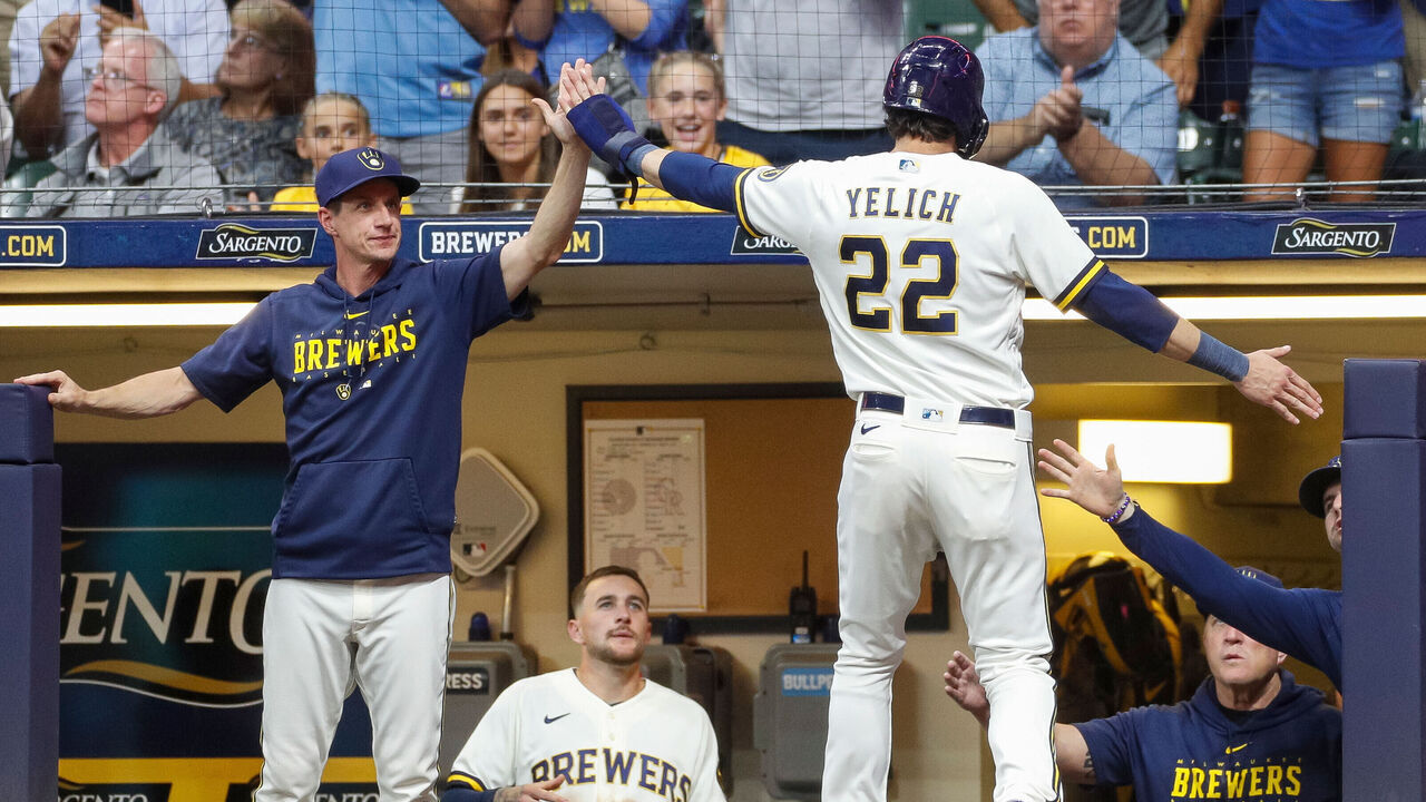 MILWAUKEE, WI - AUGUST 07: Milwaukee Brewers left fielder Christian Yelich (22) high-fives manager Craig Counsell (30), left, after scoring a run in the fourth inning during a regular season game between the Colorado Rockies and Milwaukee Brewers on August 07, 2023 at American Family Field in Milwaukee, WI.