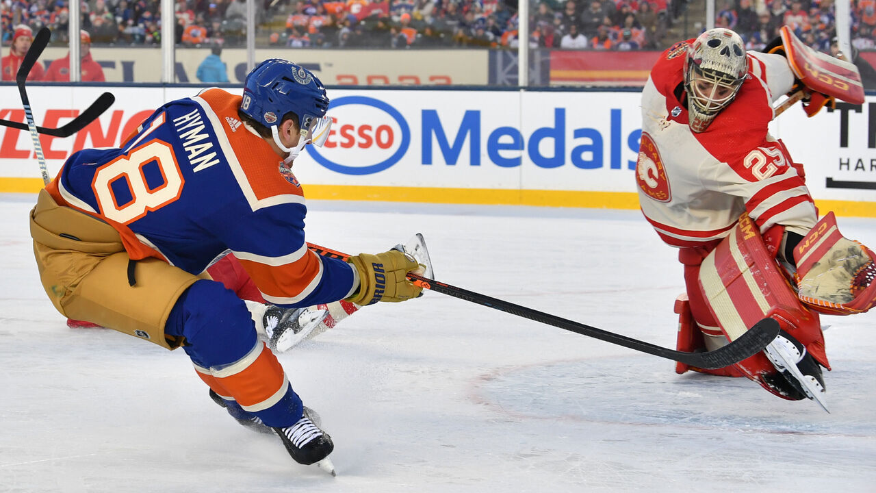 EDMONTON, CANADA - OCTOBER 29: Zach Hyman #18 of the Edmonton Oilers scores a first period goal against Jacob Markstrom #25 of the Calgary Flames at the 2023 Tim Hortons NHL Heritage Classic at Commonwealth Stadium on October 29, 2023 in Edmonton, Alberta, Canada.