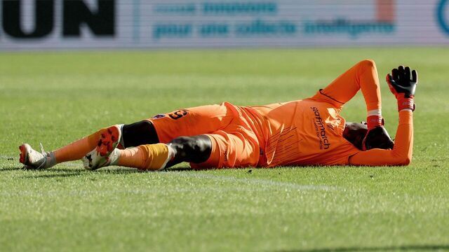 TOPSHOT - Clermont-Ferrand's French goalkeeper #99 Mory Diaw injured by a firecracker lies on the ground during the French L1 football match between Montpellier Herault SC and Clermont foot 63 at Stade de la Mosson in Montpellier, southern France on October 8, 2023.