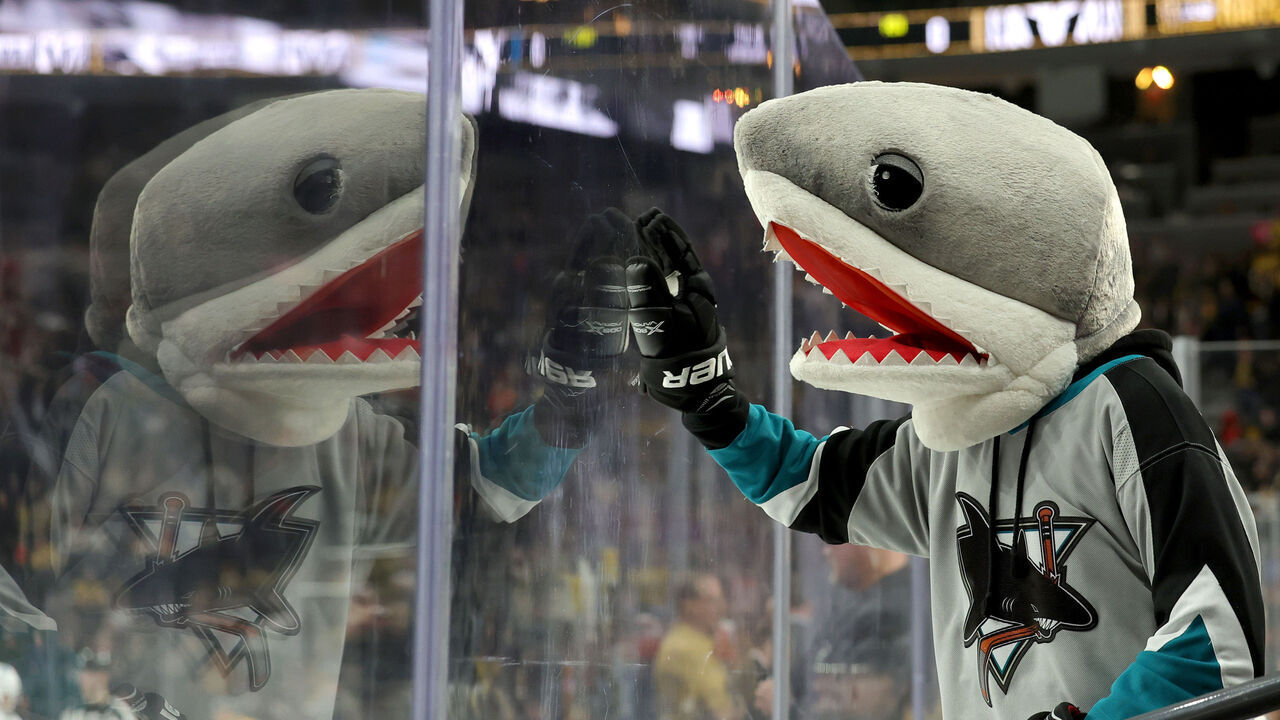 LAS VEGAS, NEVADA - FEBRUARY 16: A San Jose Sharks fan wearing a shark head bangs on the glass before the start of the second period of their game against the Vegas Golden Knights at T-Mobile Arena on February 16, 2023 in Las Vegas, Nevada.