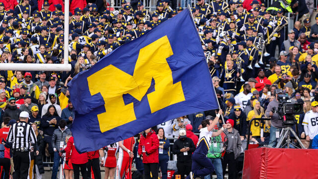 COLUMBUS, OH - NOVEMBER 26: A Michigan Wolverines cheerleader runs the Michigan banner thru the end zone after a Wolverines touchdown during the fourth quarter of the college football game between the Michigan Wolverines and Ohio State Buckeyes on November 26, 2022, at Ohio Stadium in Columbus, OH.