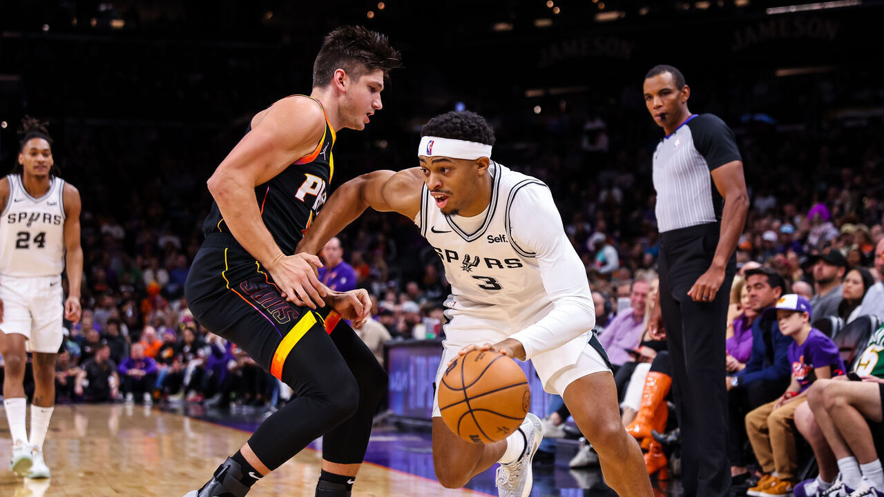 PHOENIX, ARIZONA - OCTOBER 31: Keldon Johnson #3 of the San Antonio Spurs looks to drive around Grayson Allen #8 of the Phoenix Suns during the first quarter of an NBA game at Footprint Center on October 31, 2023 in Phoenix, Arizona.
