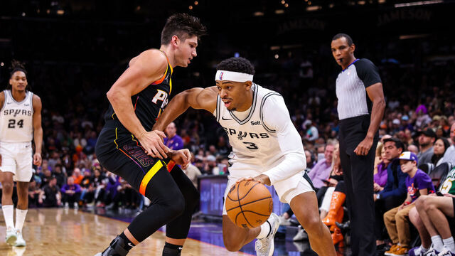 PHOENIX, ARIZONA - OCTOBER 31: Keldon Johnson #3 of the San Antonio Spurs looks to drive around Grayson Allen #8 of the Phoenix Suns during the first quarter of an NBA game at Footprint Center on October 31, 2023 in Phoenix, Arizona.
