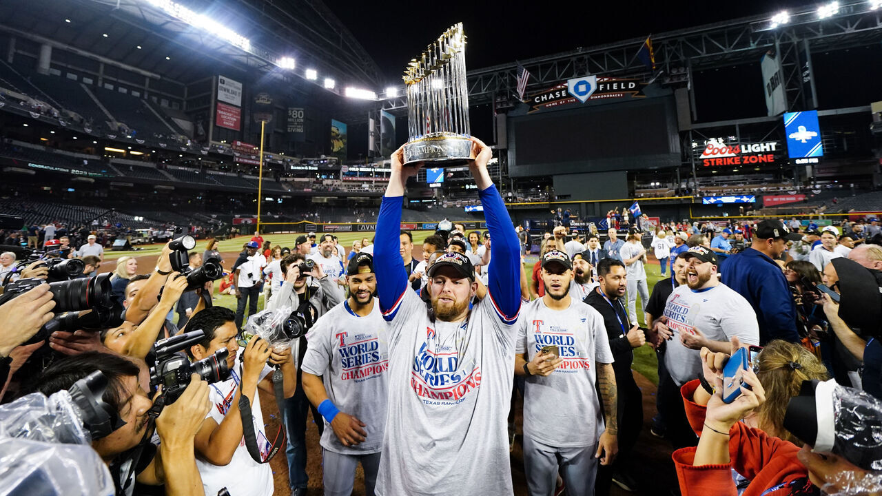 PHOENIX, AZ - NOVEMBER 01: Jordan Montgomery #52 of the Texas Rangers holds up the Commissioner's Trophy after winning Game 5 of the 2023 World Series between the Texas Rangers and the Arizona Diamondbacks at Chase Field on Wednesday, November 1, 2023 in Phoenix, Arizona. The Rangers defeated the Diamondbacks 5-0 to win the World Series.