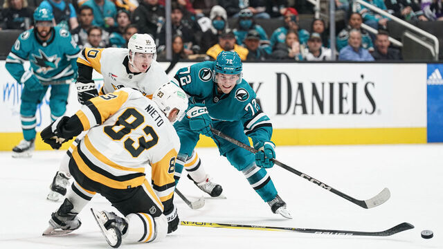 SAN JOSE, CA - NOVEMBER 4: William Eklund #72 of the San Jose Sharks passes the puck against Matt Nieto #83 of the Pittsburgh Penguins at SAP Center on November 4, 2023 in San Jose, California.