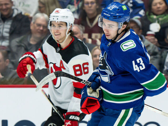 VANCOUVER, BC - MARCH 15: Vancouver Canucks defenseman Quinn Hughes (43) and New Jersey Devils center Jack Hughes (86) after a whistle during their NHL game at Rogers Arena on March 15, 2022 in Vancouver, British Columbia, Canada.