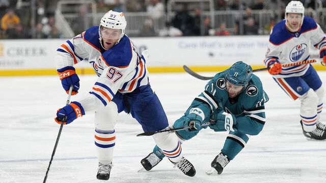 SAN JOSE, CALIFORNIA - NOVEMBER 09: Connor McDavid #97 of the Edmonton Oilers skates with the puck pursued by Luke Kunin #11 of the San Jose Sharks during the first period at SAP Center on November 09, 2023 in San Jose, California.