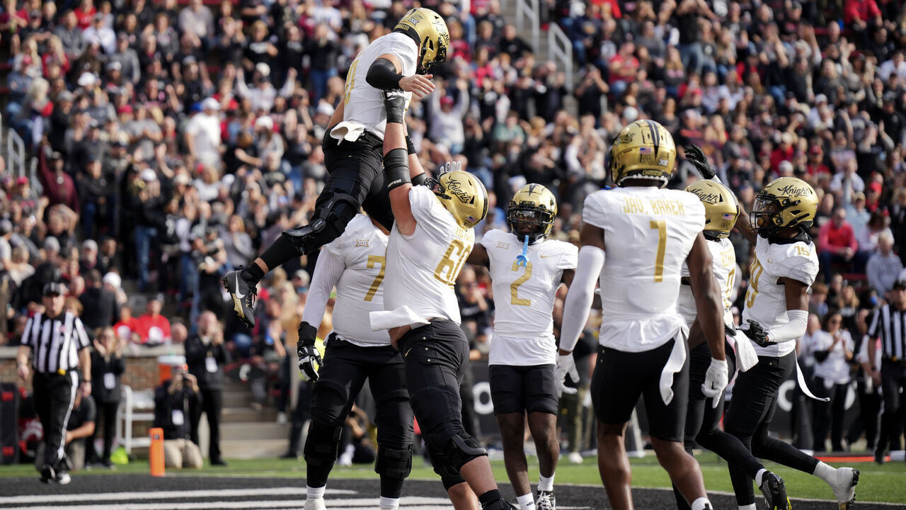 CINCINNATI, OHIO - NOVEMBER 04: John Rhys Plumlee #10 of the UCF Knights celebrates as he is lifted by Drake Metcalf #60 after scoring a touchdown in the first half against the Cincinnati Bearcats at Nippert Stadium on November 04, 2023 in Cincinnati, Ohio.