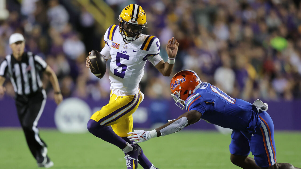 BATON ROUGE, LOUISIANA - NOVEMBER 11: Jayden Daniels #5 of the LSU Tigers runs with the ball as Scooby Williams #17 of the Florida Gators defends during the first half at Tiger Stadium on November 11, 2023 in Baton Rouge, Louisiana.