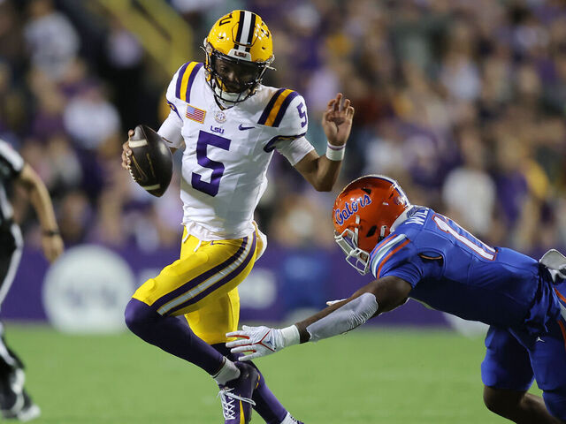 BATON ROUGE, LOUISIANA - NOVEMBER 11: Jayden Daniels #5 of the LSU Tigers runs with the ball as Scooby Williams #17 of the Florida Gators defends during the first half at Tiger Stadium on November 11, 2023 in Baton Rouge, Louisiana.