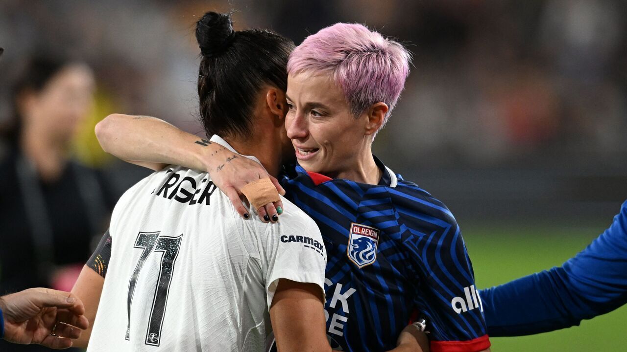 Gotham FC's US defender #11 Ali Krieger hugs OL Reign's US midfielder #15 Megan Rapinoe as she is helped off the pitch after an injury in the early minutes of the first half of the National Women's Soccer League final match between OL Reign and Gotham FC at Snapdragon Stadium in San Diego, California, on November 11, 2023. US women's football icon Megan Rapinoe limped out of the final game of her storied career, suffering an apparent ankle injury less than three minutes into the National Women's Soccer League Final.