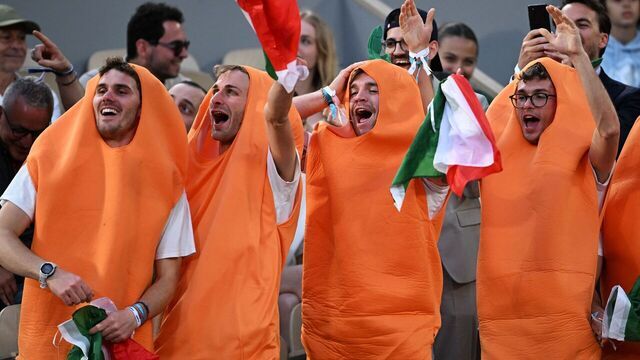 TOPSHOT - Fans of Italy's Jannik Sinner, dressed as carrots, gestures during his men's singles match against France's Alexandre Muller on day two of the Roland-Garros Open tennis tournament at the Court Philippe-Chatrier in Paris on May 29, 2023.