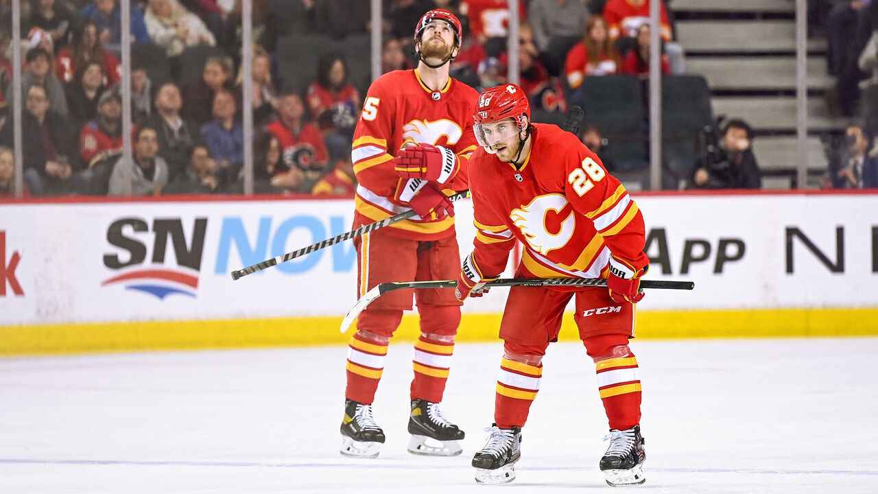 CALGARY, AB - MARCH 10: Calgary Flames Center Elias Lindholm (28) and Calgary Flames Defenceman Noah Hanifin (55) await a face-off during the second period of an NHL game where the Calgary Flames hosted the Tampa Bay Lightning on March 10, 2022, at the Scotiabank Saddledome in Calgary, AB.