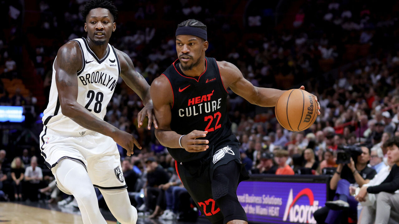 MIAMI, FLORIDA - NOVEMBER 16: Jimmy Butler #22 of the Miami Heat drives against Dorian Finney-Smith #28 of the Brooklyn Nets during the first quarter of the game at Kaseya Center on November 16, 2023 in Miami, Florida.