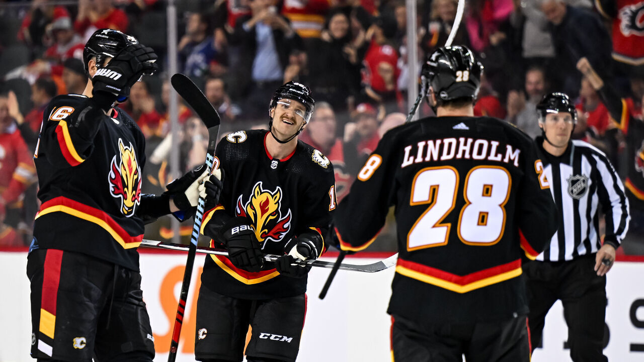 CALGARY, AB - NOVEMBER 16: Calgary Flames Defenceman Nikita Zadorov (16), Calgary Flames Left Wing Jonathan Huberdeau (10) and Calgary Flames Center Elias Lindholm (28) celebrate a goal during the third period of an NHL game between the Calgary Flames and the Vancouver Canucks on November 16, 2023, at the Scotiabank Saddledome in Calgary, AB.