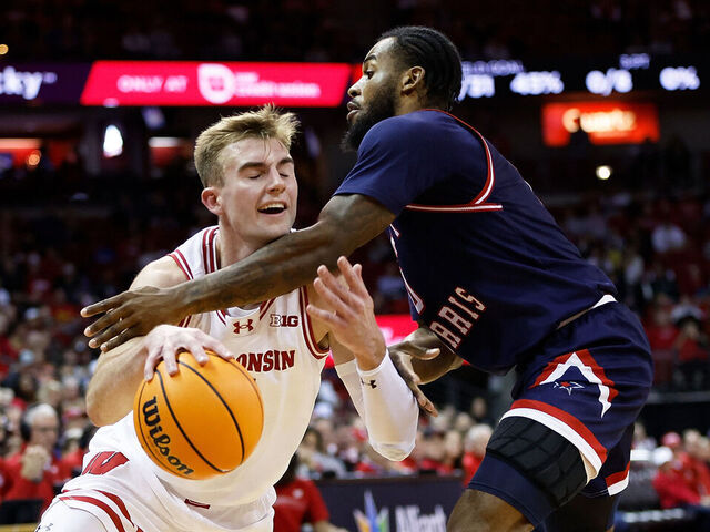 MADISON, WISCONSIN - NOVEMBER 17: Tyler Wahl #5 of the Wisconsin Badgers is fouled going to the basket by Markeese Hastings #0 of the Robert Morris Colonials during the second half at Kohl Center on November 17, 2023 in Madison, Wisconsin.