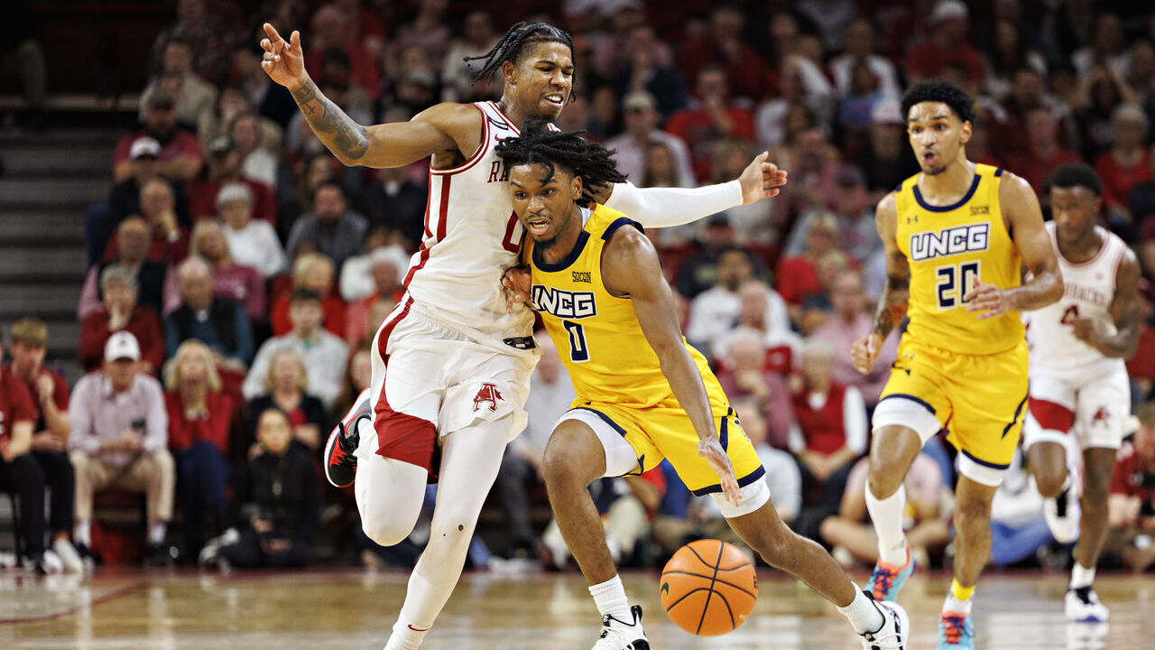 FAYETTEVILLE, ARKANSAS - NOVEMBER 17: Keyshaun Langley #0 of the UNC Greensboro Spartans dribbles the ball down the court in the first half against Khalif Battle #0 of the Arkansas Razorbacks at Bud Walton Arena on November 17, 2023 in Fayetteville, Arkansas.