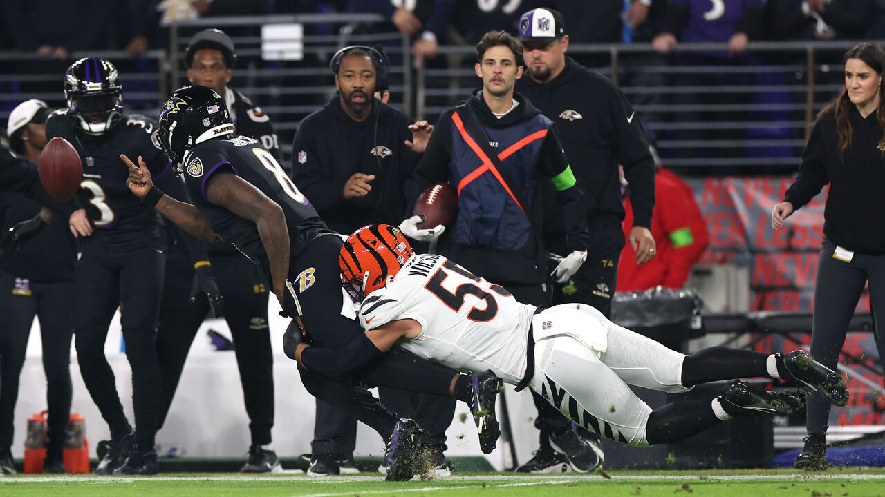 BALTIMORE, MARYLAND - NOVEMBER 16: Logan Wilson #55 of the Cincinnati Bengals tackles Lamar Jackson #8 of the Baltimore Ravens during the first quarter of the game at M&T Bank Stadium on November 16, 2023 in Baltimore, Maryland.