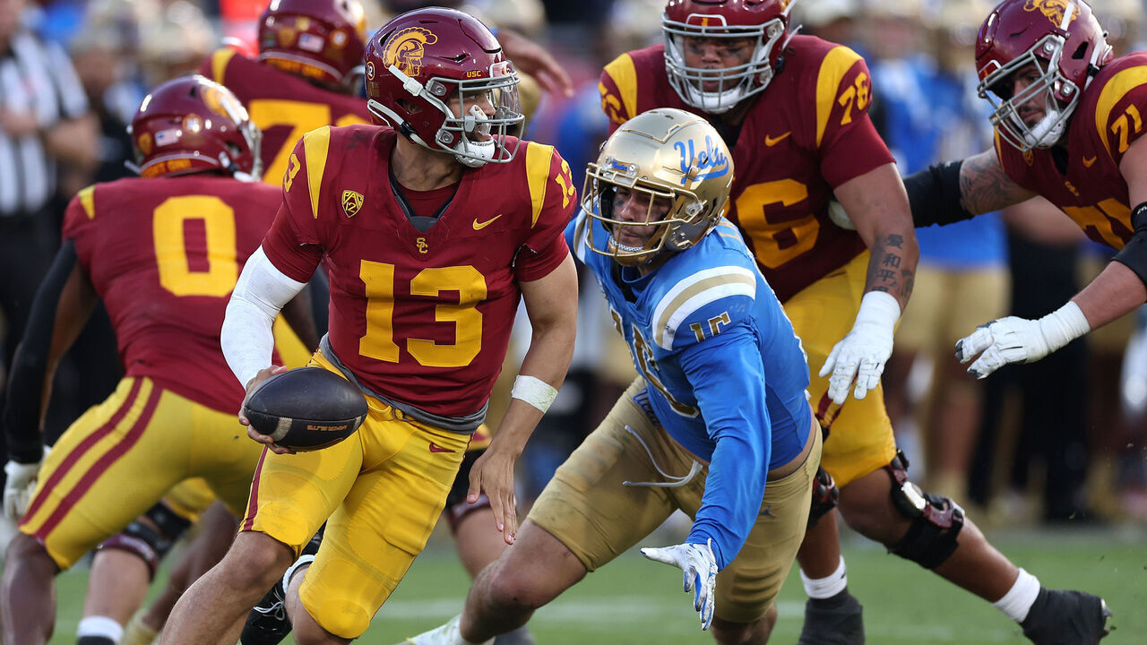 LOS ANGELES, CALIFORNIA - NOVEMBER 18: Caleb Williams #13 of the USC Trojans is flushed from the pocket by Laiatu Latu #15 of the UCLA Bruins during the second half of a game at United Airlines Field at the Los Angeles Memorial Coliseum on November 18, 2023 in Los Angeles, California.