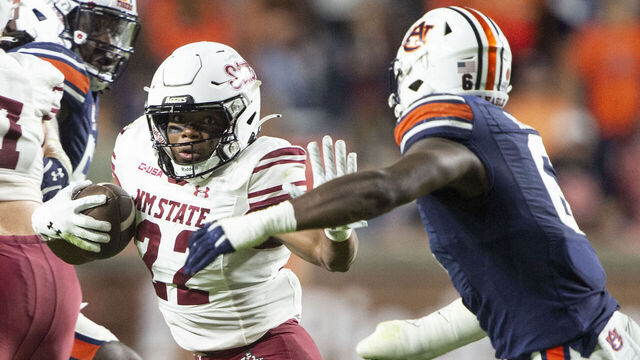 AUBURN, ALABAMA - NOVEMBER 18: Running back Makhilyn Young #22 of the New Mexico State Aggies looks to maneuver the ball by linebacker Austin Keys #6 of the Auburn Tigers during the second half of play at Jordan-Hare Stadium on November 18, 2023 in Auburn, Alabama.