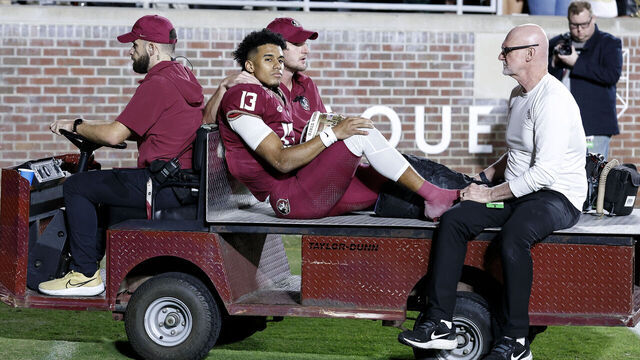 TALLAHASSEE, FL - NOVEMBER 18: Quarterback Jordan Travis #13 of the Florida State Seminoles is carted off the field after an ankle jury during the game against the North Alabama Lions on Bobby Bowden Field at Doak Campbell Stadium on November 18, 2023 in Tallahassee, Florida. The 4th ranked Seminoles defeated the Lions 58 to 13.