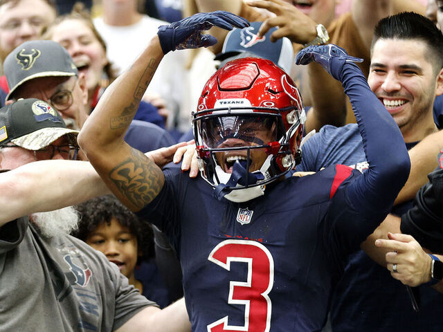 HOUSTON, TEXAS - NOVEMBER 19: Tank Dell #3 of the Houston Texans climbs into stands after a second quarter touchdown during a game against the Arizona Cardinals at NRG Stadium on November 19, 2023 in Houston, Texas.