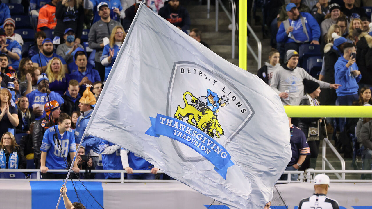 A member of the Lions cheer team runs with a flag after a Lions touchdown during an NFL football game between the Detroit Lions and the Chicago Bears in Detroit, Michigan USA, on Thursday, November 25, 2021.